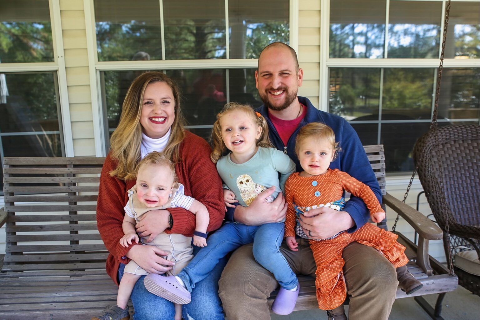 The Noble family posing together for a photo on their front porch.