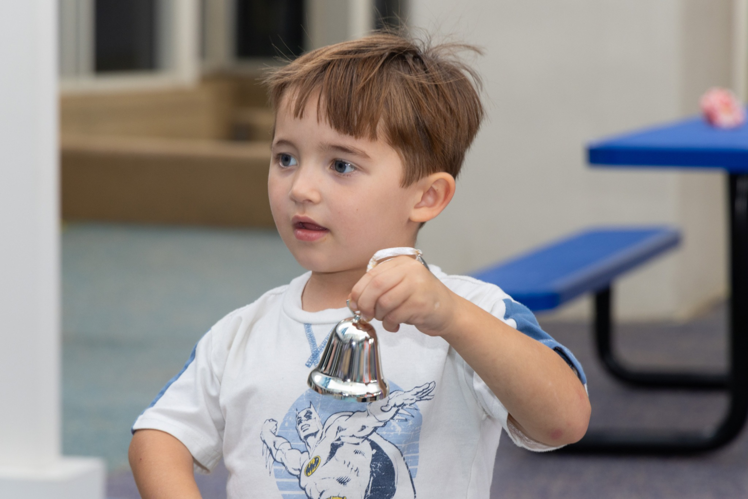 Claud holding a silver bell in play.