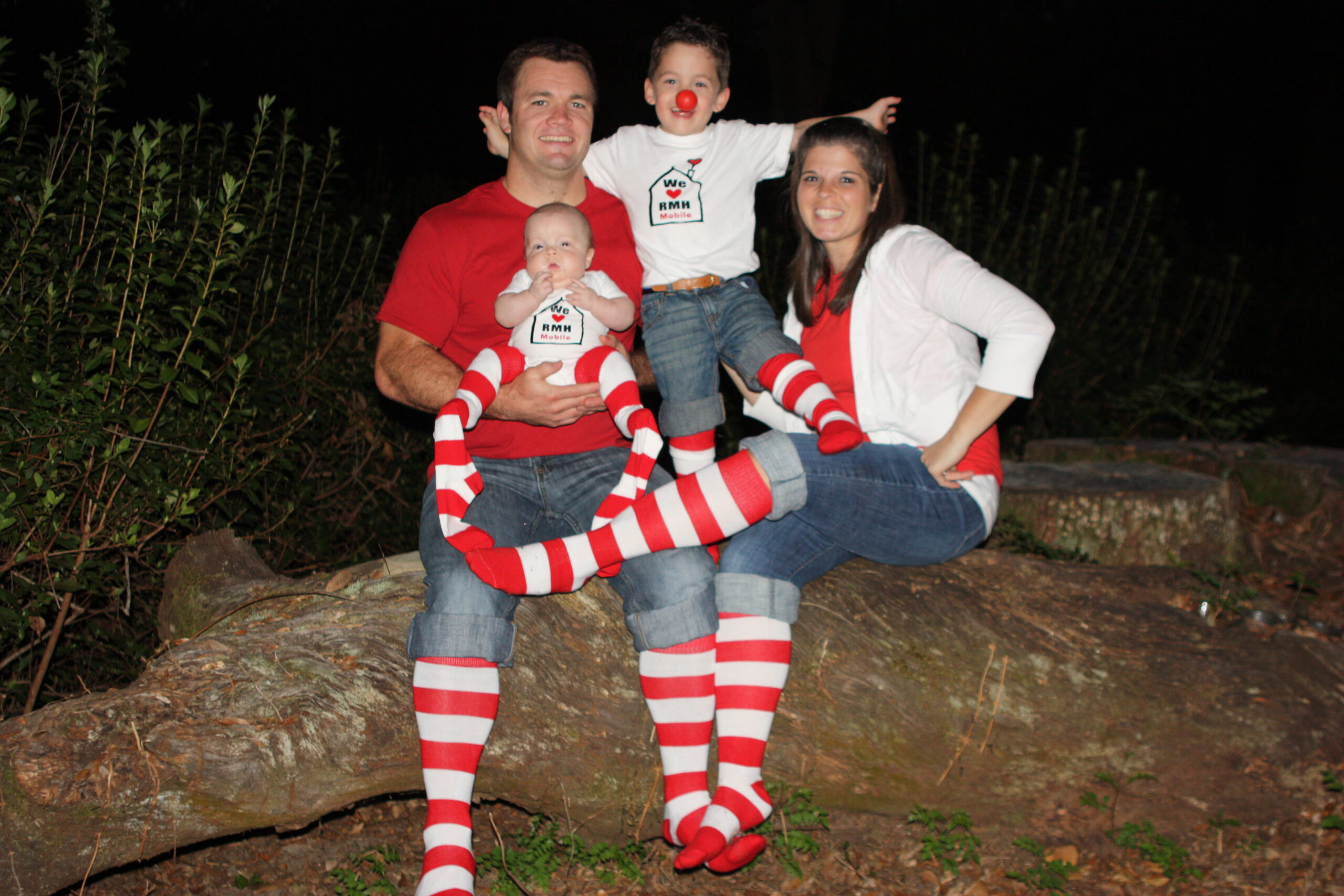 The Perkins family dressed in Ronald McDonald red posing for a photo.