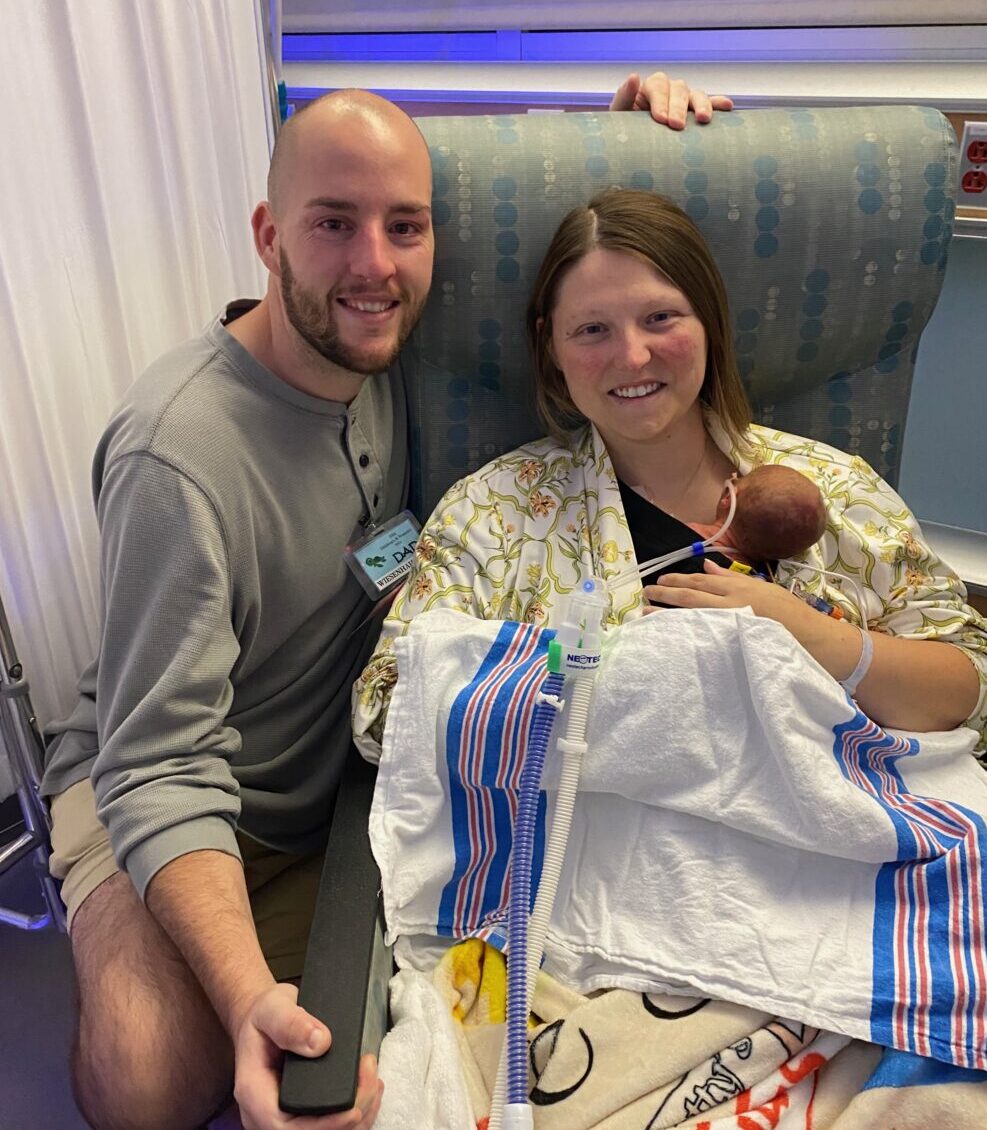 The Simmons sitting with baby Leo at the hospital.